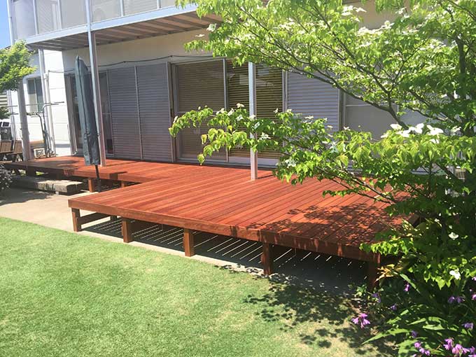 室内から庭へつながる動線が確保されたL型ウッドデッキの外観写真